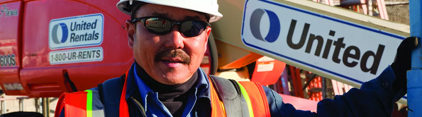 man in construction ppe next to boom lift