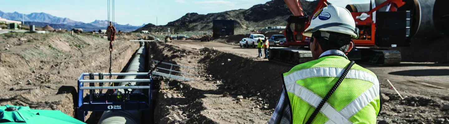 Construction manager looks at trench site