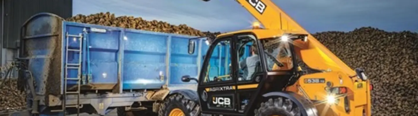Standby compaction roller parked near construction barriers, ready for ground stabilization work on the site.