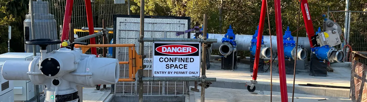 Construction site with various materials scattered and a warning sign indicating a dangerous confined space for safety awareness.