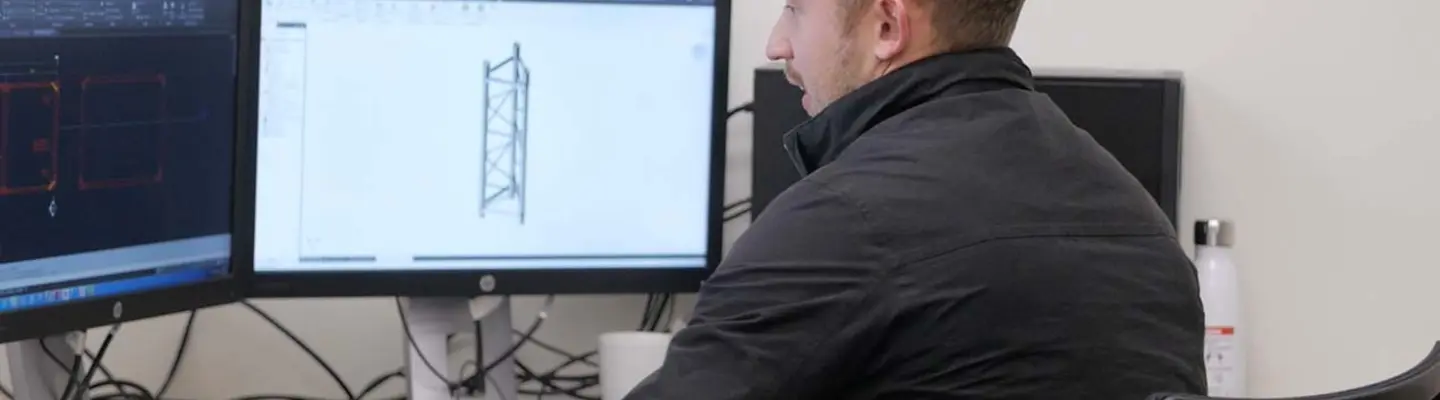 Engineer working at a computer, creating structural designs for construction site safety and temporary support systems.