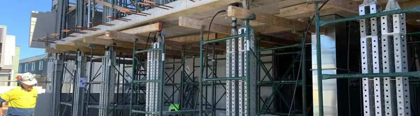 Workers installing temporary supports and braces at a construction site to stabilize structures during the building process.