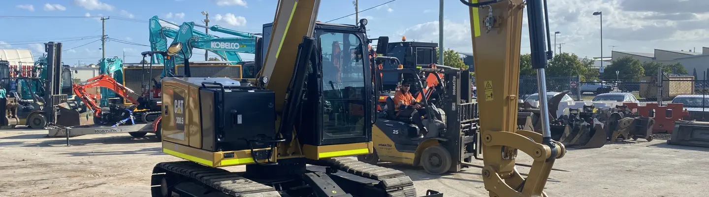 Parked excavator, positioned near safety barriers used for site control and hazard prevention.