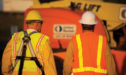 Two workers wearing personal protective equipment