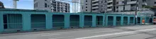 Covered container walkway at construction site, providing safe pedestrian access and separation from active work zones.